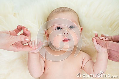 Baby girl holding parents hands Stock Photo