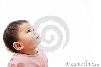 A baby girl looks up with pink clothes, not looking camera Stock Photo