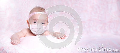 The baby girl is in a medical mask with a bow on her head. Concept pandemic coronavirus Covid 19 Stock Photo