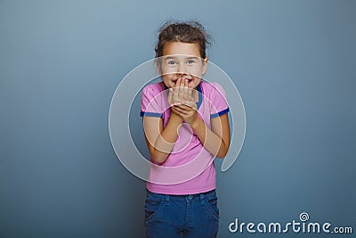 Baby girl oops hand to mouth on gray background Stock Photo