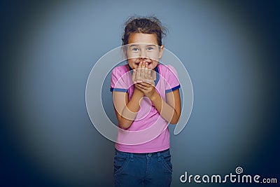 Baby girl oops hand to mouth on gray background Stock Photo
