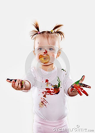 The baby girl with a pacifier in gouache soiled hands and shirt isolated Stock Photo