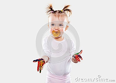 The baby girl with a pacifier in gouache soiled hands and shirt isolated Stock Photo