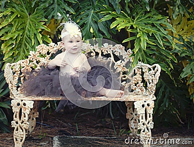 Baby girl on park bench Stock Photo