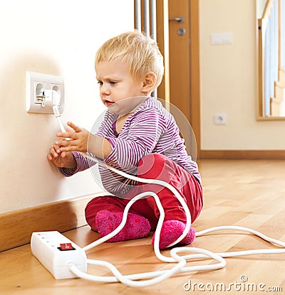 Baby girl playing with electrical extension Stock Photo