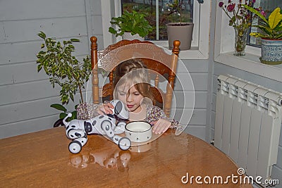 Baby girl playing robot dog video without processing Stock Photo