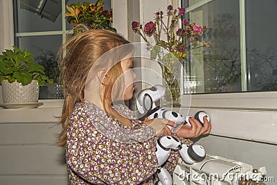 Baby girl playing robot dog video without processing Stock Photo