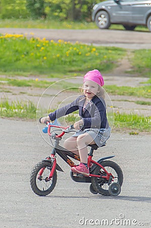 Baby girl riding her bike on a Sunny day. Stock Photo