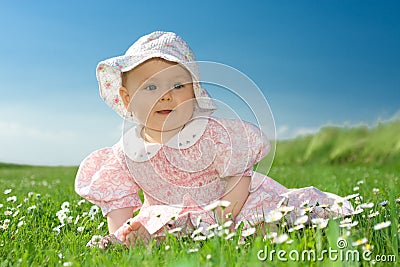 Baby girl sat in flowery field Stock Photo