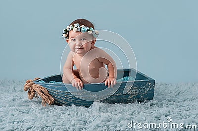 Baby Girl Sitting in a Little Boat Stock Photo