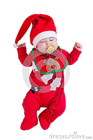 Baby girl sleeping or asleep with pacifier or dummy, red onesie, Rudolph reindeer bib, Santa hat for Christmas. Stock Photo