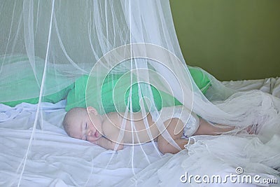 Baby girl sleeping under mosquito net Stock Photo