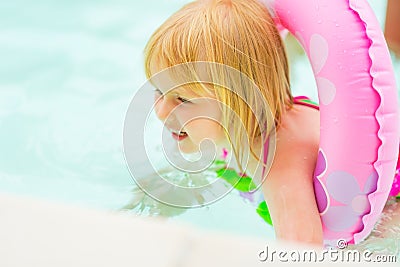 Baby girl with swim ring swimming in pool Stock Photo