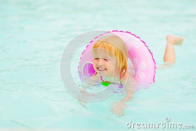 Baby girl with swim ring swimming in pool Stock Photo