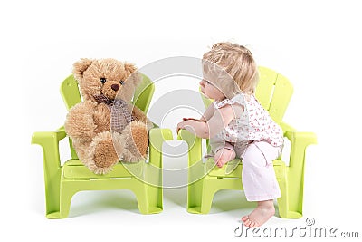 Baby Girl Talks with Her Toy Bear Stock Photo