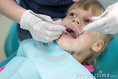 Baby girl visiting stomatology clinic. Dentist making checkup of kids teeth. Children tooth and mouth healthcare Stock Photo