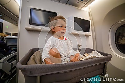 Baby girl wake up afret sleeping In Bassinet On Airplane Stock Photo