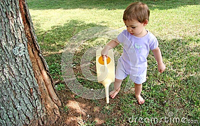 Baby Girl Watering Lawn Stock Photo