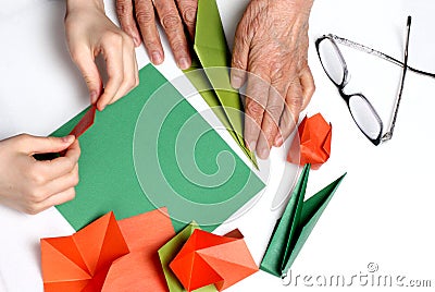 Baby and grandma make origami Stock Photo