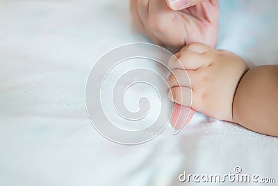 Baby hand on the bed, soft focus newborn tiny hand, Children hand gently holding mother of love with family. Stock Photo