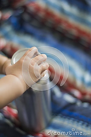 Baby hand grabbing Stainless Bottle in the living room Stock Photo