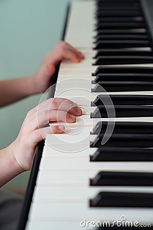 Baby hands black white piano keys synth. close-up. Stock Photo
