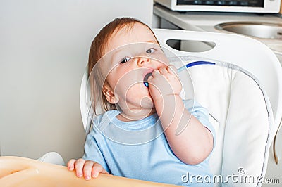 Baby in highchair covered in fruit, vegetable puree close-up. Complementary feeding tredhead oddler concept Stock Photo