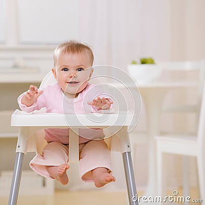 Baby in highchair waiting to be fed Stock Photo