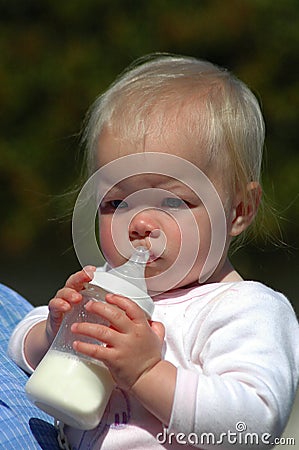 Baby holding bottle Stock Photo