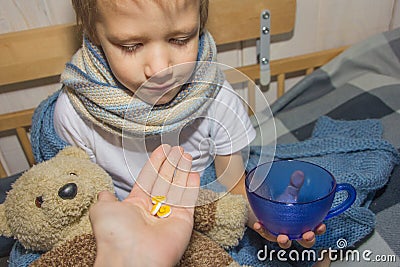 The baby is ill. The child takes the pill. Stock Photo