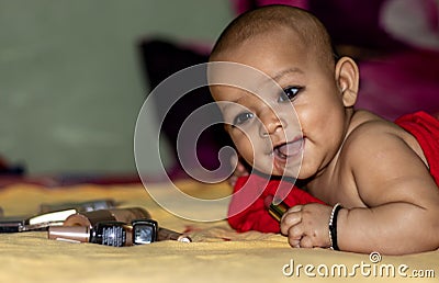 Baby infant cute holding lipstick with blurred background Stock Photo