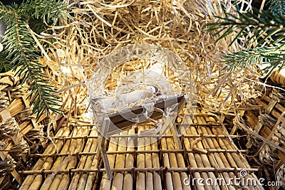 Baby Jesus resting on a manger with light from the star filters through window Stock Photo