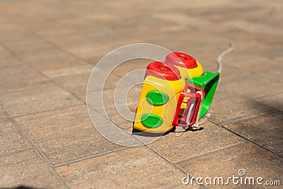 Baby kids toy background: toy colored car knocked over on the paving stone. Stock Photo