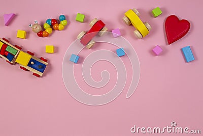 Baby kids toys frame with teddy bear, toy car, wooden train, colorful bricks on pink background. Top view Stock Photo