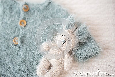 Baby knitted suit in blue and bunny toy Stock Photo