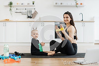 Baby learning exercises with stretch band from mom at home Stock Photo