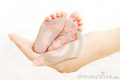 Baby legs in mother hands Stock Photo
