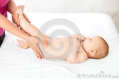 Baby loves the massage the leg muscles. masseuse doing massage to the baby Stock Photo