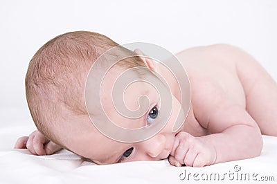 Baby lying and sucking finger Stock Photo