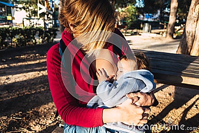 Baby naps while being breastfed by his mother outdoors Stock Photo