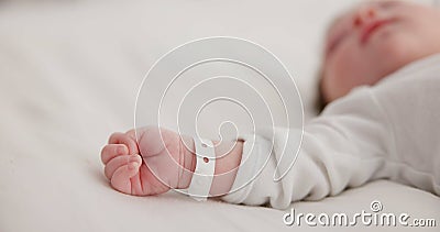 Baby, new born and hand with bracelet on bed for care, trust or support in hospital for birth. Infant, love and hope Stock Photo