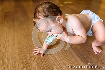 Baby nibbling a 1 dollar bill Stock Photo