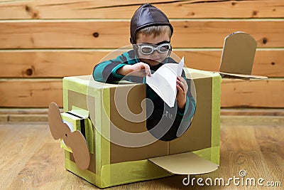 Baby play in cardboard plane, childhood. Pilot travel, airdrome, imagination. Kid, pilot school, innovation. Dream kids Stock Photo