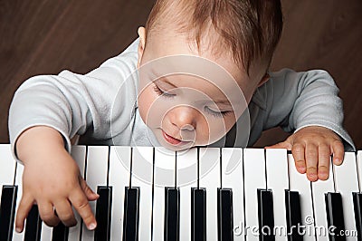 Baby play music on piano keyboard Stock Photo