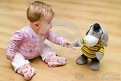 Baby playing with cuddly toy Stock Photo