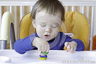 Baby playing with plasticine Stock Photo