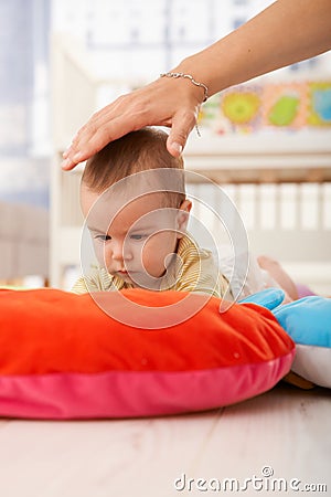 Baby on playmat concentrating Stock Photo