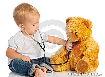 Baby plays in doctor toy bear, stethoscope Stock Photo