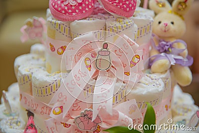 Used for decoration when the child leaves the hospital . Pink children`s shoes . Rabbit toys . ribbon . Baby pram made of diapers Editorial Stock Photo