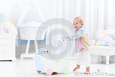 Baby with push walker in white bedroom Stock Photo